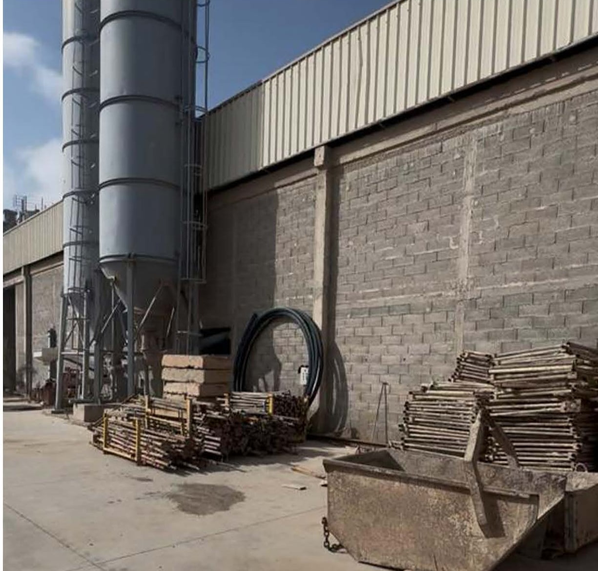 Silos de ciment devant un mur en blocs béton et bardage métallique